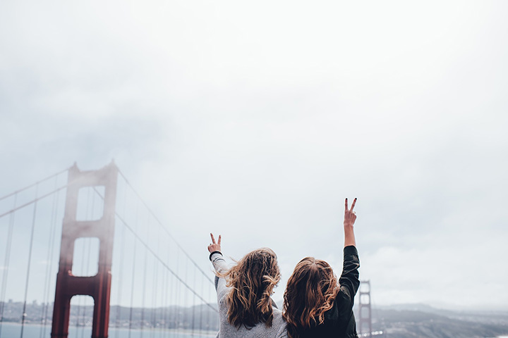 two women waving on Golden Gate Bridge